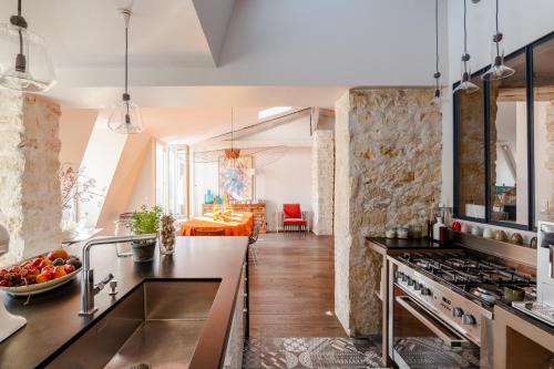 une cuisine avec un évier et une cuisinière dans l'établissement Veeve - Soulful Fusion, à Paris