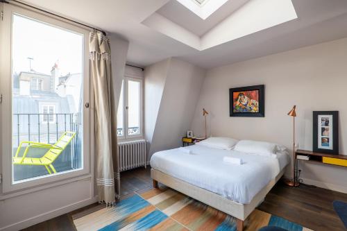 une chambre avec un lit et une grande fenêtre dans l'établissement Veeve - Soulful Fusion, à Paris