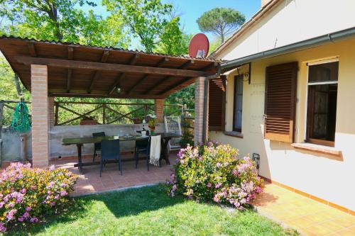 een patio met een houten pergola naast een huis bij ISA-Chalet Elena in Montescudaio, with air conditioning, on the ground floor with fenced garden in Montescudaio