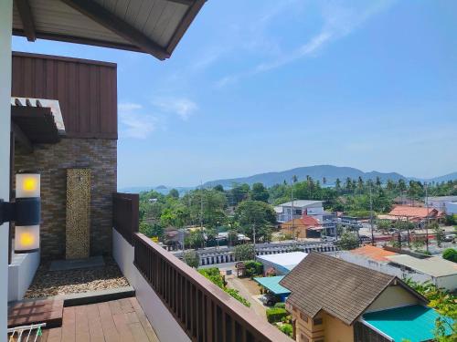 a balcony with a view of a city at Ratana Hotel Chalong in Rawai Beach