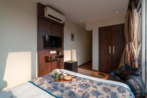 a hotel room with a bed and a tv at Riva Gold Coast in Candolim
