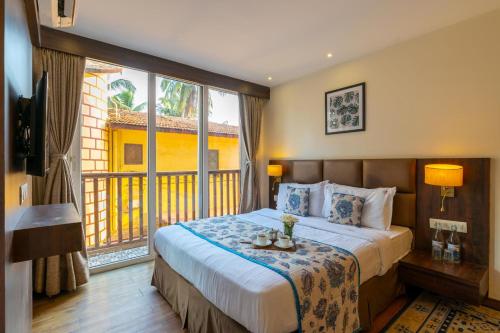 a bedroom with a large bed and a large window at Riva Gold Coast in Candolim