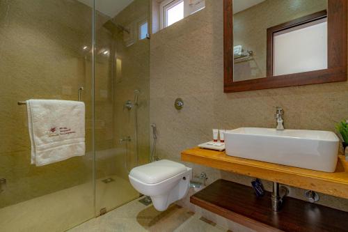 a bathroom with a sink and a toilet and a shower at Riva Gold Coast in Candolim