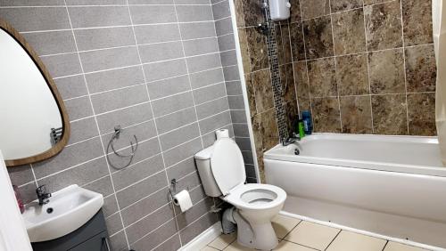 ein Badezimmer mit einem WC, einer Badewanne und einem Waschbecken in der Unterkunft 2 bedroom apartment, free parking & WIFI near City Centre in Manchester