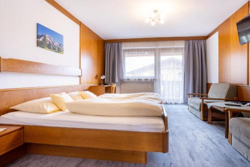 ein Hotelzimmer mit einem Bett und einem Sofa in der Unterkunft Gästehaus Wilhelmshof in Ehrwald