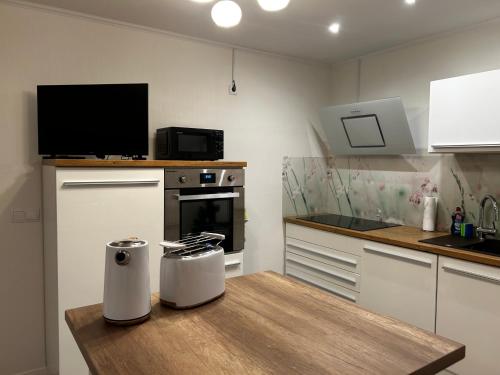 a kitchen with a wooden table with a tv on it at Apartment am Deister in Barsinghausen