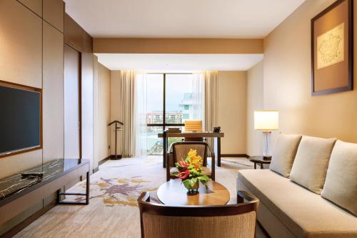a living room with a couch and a tv at Hilton Kota Kinabalu in Kota Kinabalu