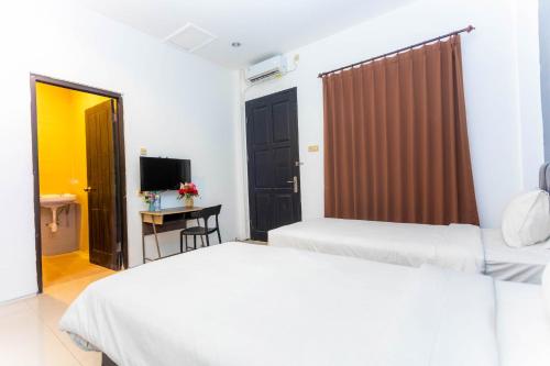 Livinn Hotel Kendangsari Surabaya في سورابايا: غرفة فندقية بسريرين ومكتب