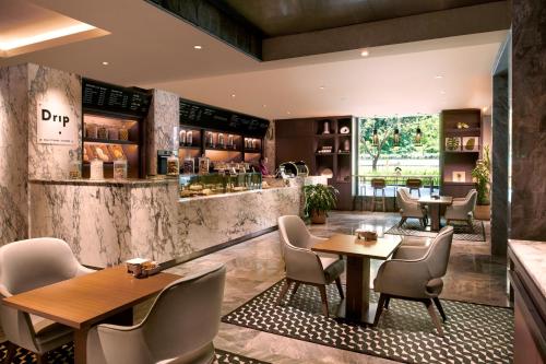 a restaurant with tables and chairs and a bar at Hilton Kota Kinabalu in Kota Kinabalu