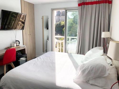 Un dormitorio con una gran cama blanca y una ventana en Hôtel Beau Soleil en Pornic