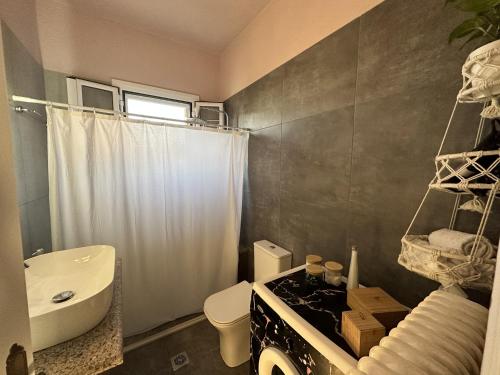 a bathroom with a sink and a toilet and a shower at Marble's Residence in Argostoli