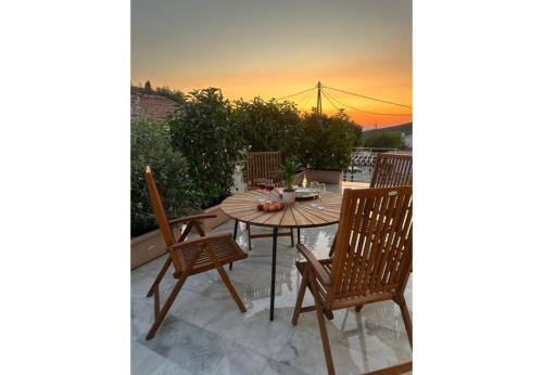 a wooden table and chairs on a patio at Marble's Residence in Argostoli