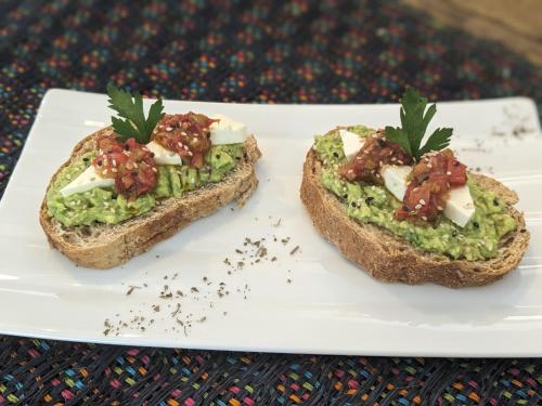 a white plate with two pieces of bread with guacamole at Perla de Fuego Casa de Huespedes in Barichara