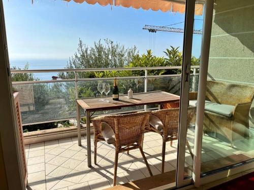 d'une terrasse avec une table et des chaises sur un balcon. dans l'établissement Les Jardins de Monaco vue mer et piscine, à Saint-Antoine