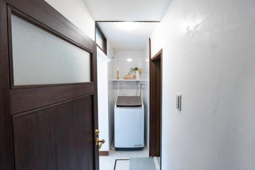 a door leading into a bathroom with a refrigerator at Rakumankan in Kyoto