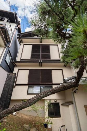 a building with windows and a tree in front of it at Rakumankan in Kyoto
