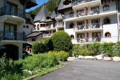 un grand bâtiment blanc avec des personnes sur les balcons dans l'établissement Résidence Le Cristal Apartments - Happy Rentals, à Chamonix-Mont-Blanc