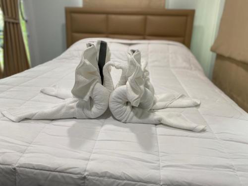 a pile of white towels on a bed at WHITE Houseรีสอร์ท in Ban Bung Thap Tae (1)