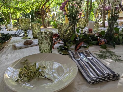 a table with a white plate and glasses on it at Perla de Fuego Casa de Huespedes in Barichara