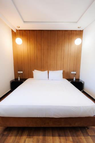 a bedroom with a large white bed with wood paneling at WINDSOR HOTEL CITY CENTER in Casablanca