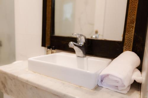 a bathroom sink with a towel next to a mirror at WINDSOR HOTEL CITY CENTER in Casablanca