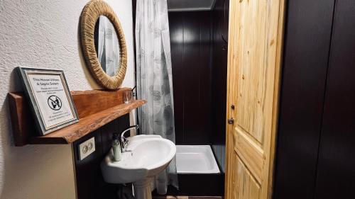 een badkamer met een wastafel en een spiegel bij Surf Dacha Hostel in Karakol