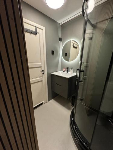 W łazience znajduje się umywalka i lustro. w obiekcie NEW! Modern - Central - Cozy place by the Sherpa stairs w mieście Tromsø