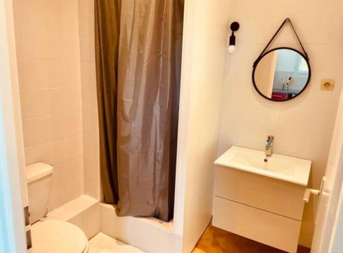 W łazience znajduje się umywalka, toaleta i lustro. w obiekcie CAVALOC T2 terrasse vue colline w mieście Cavalaire-sur-Mer