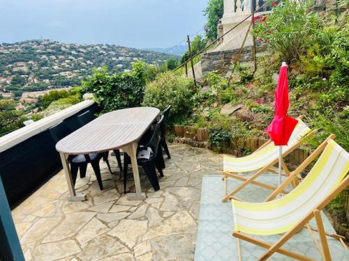 einen Tisch und Stühle auf einer Terrasse mit Aussicht in der Unterkunft CAVALOC T2 terrasse vue colline in Cavalaire-sur-Mer