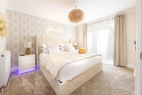 a white bedroom with a large bed and a window at The Koko Rooms in Inverness