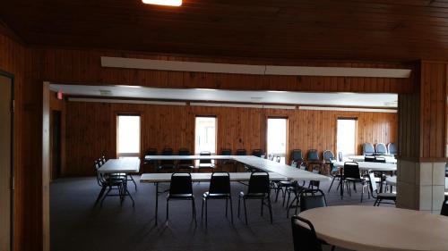 a large room with tables and chairs and windows at Woodland Inn & Suites in Medford