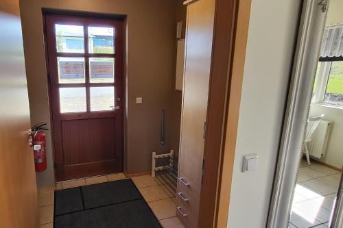 a hallway with a wooden door and a window at Kind guesthouse - the village in Búðardalur