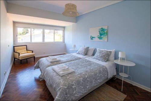 a bedroom with a bed and a chair and a window at Cascais Center Dream House in Cascais