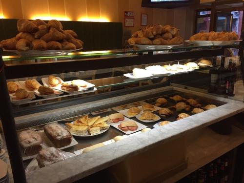 una línea de buffet con diferentes tipos de pan y repostería en Hostal Libertad en Gijón