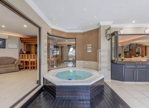 a large bathroom with a tub in a room at Palms On Byrne: Where Elegance Meets Serenity in Durban