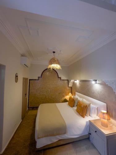 a bedroom with a large white bed and two lamps at Riad Jonan & Spa in Marrakech