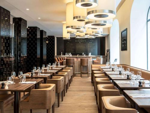 a restaurant with tables and chairs and a bar at Sofitel Paris Arc De Triomphe in Paris