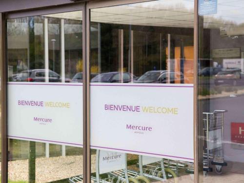 un cartel en una puerta de cristal de una tienda en Hotel Mercure Angers Lac De Maine, en Angers