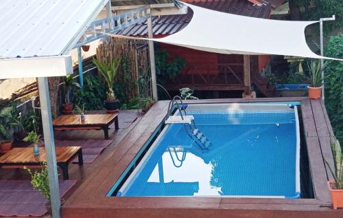 an overhead view of a swimming pool with a white umbrella at Bamboo Hostel in Thakhek