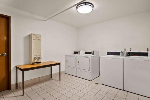 a laundry room with white appliances and a table at Best Western Northwoods Lodge in Siren