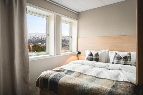 a bedroom with a bed and two windows at Enter St Elisabeth Hotel & Spa in Tromsø