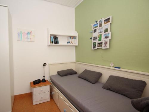 Bett in einem Zimmer mit grüner Wand in der Unterkunft Bungalow, Berumburg in Berumbur