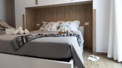 une chambre avec un grand lit avec une tête de lit en bois dans l'établissement La Casa Di Marty Per 6, à Torre del Lago Puccini