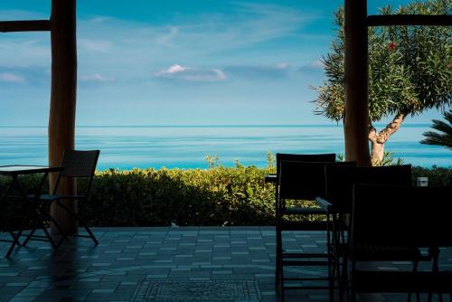 een patio met stoelen en uitzicht op de oceaan bij Residence New Paradise in Tropea