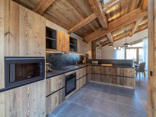 une cuisine avec des armoires en bois et un comptoir dans l'établissement Chalet de luxe familial avec piscine et sauna, proche des pistes et commodités à Courchevel Le Praz - FR-1-568-37, à Courchevel