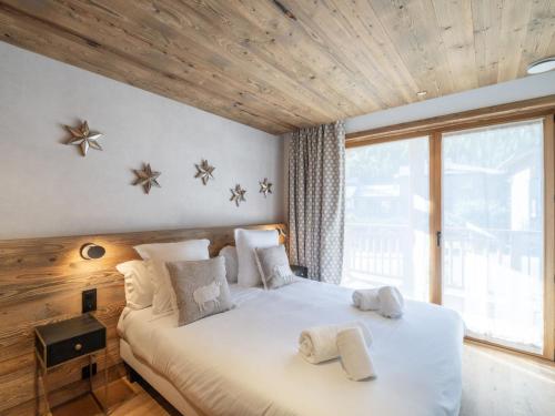 una camera da letto con un grande letto con due asciugamani di Chalet Courchevel, 6 pièces, 12 personnes - FR-1-568-37 a Courchevel