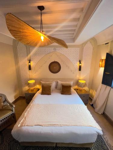 a bedroom with a large white bed with a ceiling at Riad Jonan & Spa in Marrakech