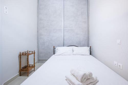 a bedroom with a white bed with towels on it at Bright Apartment In Piraeus in Piraeus