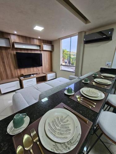 una sala de estar con una mesa con platos y utensilios. en 204 - Loft de luxo com Alexa e Ar condicionado, en Belo Horizonte