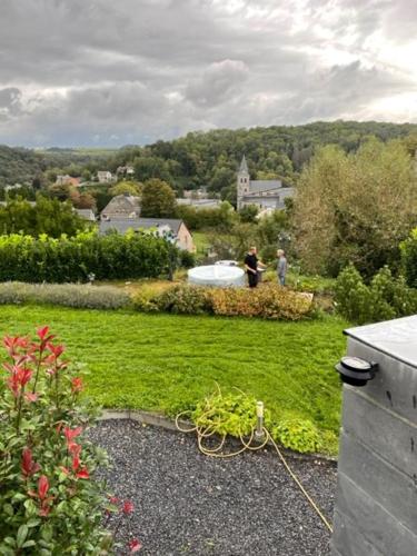 a view of a garden with people in the background at B&B Le Bouchat-Oreille in Spontin